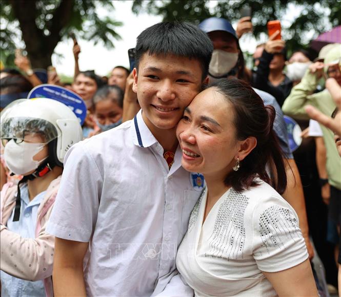 Phụ huynh vui mừng đón thí sinh sau khi hoàn thành môn thi đầu tiên tại điểm thi Trường THPT Trần Nhân Tông. Ảnh: Thanh Tùng - TTXVN